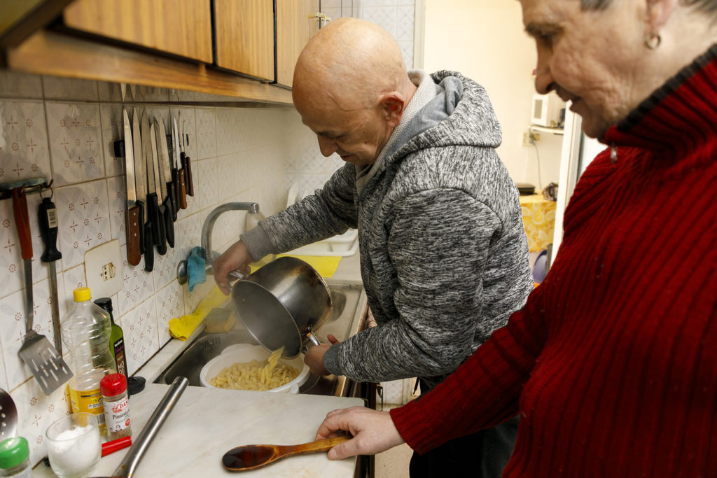 Dos residents del servei d'habitatge cuinant uns macarrons